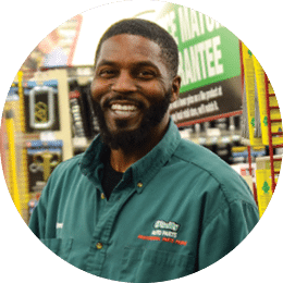 A man in a green jacket is smiling and holding a beverage. AI generated content